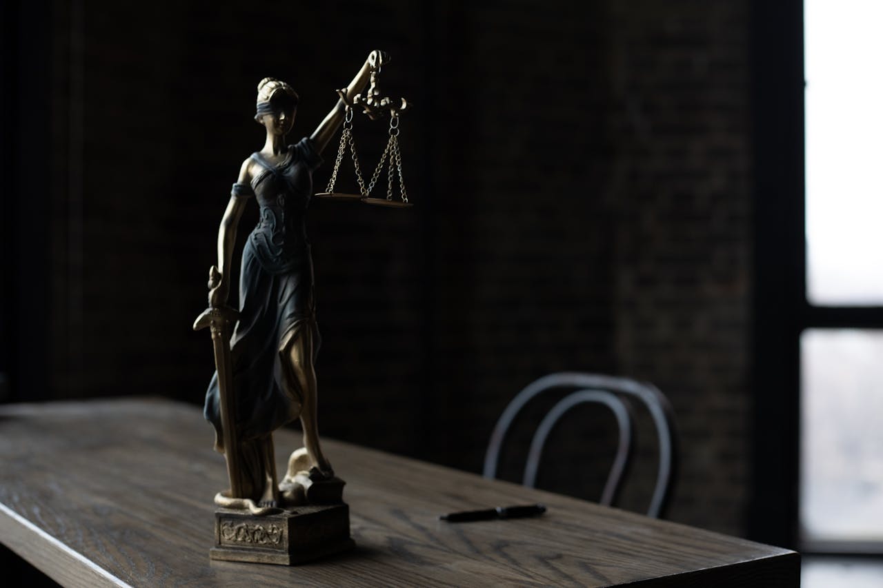 桌上擺著象徵審判與公平的正義女神雕像，象徵內心那位總是批判自己的法官