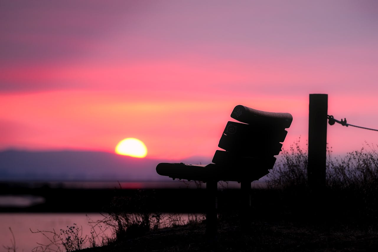 夕陽下的空椅靜靜坐落在湖畔，象徵獨處中與自己對話的寧靜時刻
