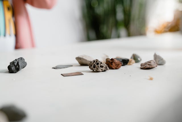 雙手捧著五顆彩色石頭,象徵《男孩與冒險家》中小男孩的「原則石頭」──相信、善念、毅力、忠誠與勇氣,提醒我們帶著原則前行。